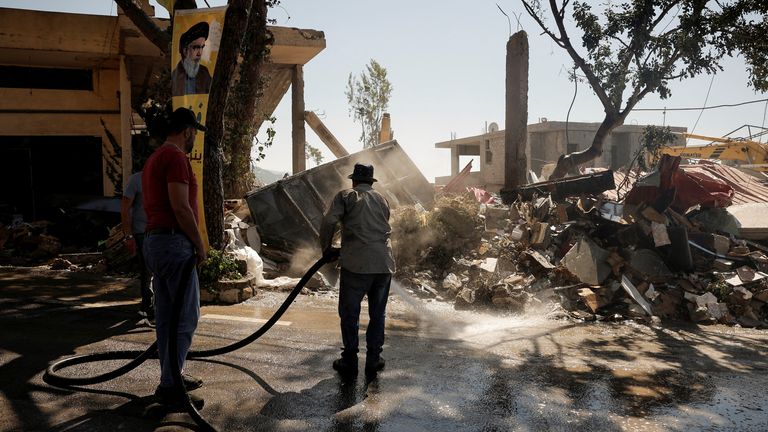 People clean the streets a day after an Israeli strike on residential buildings in the village of Maaysrah, north of Beirut. Pic: Reuters